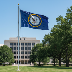 Flag of the United States Navy flying in front of a building with trees in the background