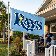 Tampa Bay Rays flag on a Florida home flagpole with baseball fans enjoying a watch party